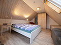 Gemütliches Schlafzimmer mit hellen Holzmöbeln